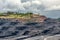 A large quarry with many horizons and ledges. Vertical bedding of coal seams.