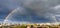 A large rainbow in the cloudy sky over the city after heavy rain