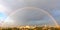 Large rainbow semicircle in the cityscape of the daytime sky