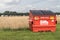 Large red Biffa General Waste container garbage rubish bin in a field