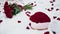 A large red bouquet of roses and a box of flowers in the shape of a heart for Valentine\'s Day lies on a snow-white bed