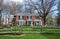 Large Red Brick Country Home with Split Rail Fence