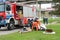 A large red fire rescue vehicle, a truck to extinguish a fire and male firefighters are prepared to work at a chemical, petroleum