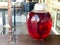 A large red transparent glass round luminous bright jar, the capacity of a delicious sweet juice, a hamper, a mors, wine, liquid s