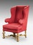 Large red wing chair upholstered in red old antique in need of r