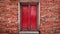 Large red wooden door and red brick wall texture background. The old vintage retro door made of hardwood