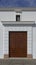 A large reinforced wooden side door of a whitewashed wall in a Church in the Spanish Town of Antequerra.