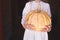 Large ripe orange pumpkin in hands of a girl in a beige sweater on a dark background. Halloween, thanksgiving.