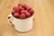 Large ripe raspberries in a mug