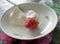 Large ripe strawberry berry on a plate with sour cream, macro