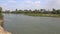 Large River Surrounded by Soil and Trees in Flat Plain