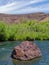 A large rock lodged in the middle of the Owyhee River in Oregon, USA