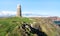 A large rock tower sits near a coastal cliff in Scotland