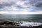 Large rocks, many clouds, and the horizon on a seascape