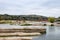 Large rocks in the water in the Pedernales River in the autumn in Texas with tourists sitting on rocks in distance and insulators