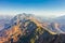 Large rocky mountain range with peaks and troughs, aerial view on a clear sunny day with good weather