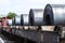 Large rolls of sheet metal lying on a freight wagon pulled by locomotives.