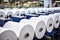 Large rolls of white paper sit on a machine in a factory, ready to be processed.