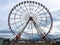 A large round beautiful Ferris wheel, a panoramic platform in a park on a tropical sea warm summer resort with palm trees