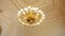 Large round gold antique chandelier hanging on the ceiling