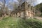 Large ruined scrubby house with build in windows on sunny day