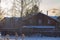 A large Russian wooden bath made of logs is heated in winter in the cold with firewood