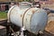 Large rusty steel barrel for technical water at construction site