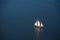 A large sailboat goes to sea under sail. View from above.