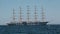 Large sailing ship with five masts anchored in the open sea.