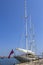 A large sailing ship stands in the port on the dock with the sails lowered.