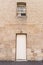 Large sandstone wall with white door