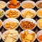 Large savoury snack food selection in porcelain bowls