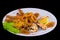 Large selection of fried seafood snacks. Stuffed mussels, breaded squid rings, sea cocktail, tiger prawns with lemon. Closeup on a