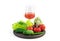 A large selection of vegetables and a Glass of freshly squeezed vegetable juice on a round tray on a white background.