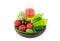 A large selection of vegetables and a Glass of freshly squeezed vegetable juice on a round tray on a white background.