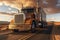 A large semi truck driving down a desert road at sunset