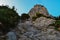 large sharp rock, cliff among green trees, bushes, forests. Crimea. Summer landscape. Bottom view