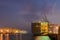 Large ship with operating crane at harbor night time