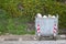 Large silver trash can with trash around it on a street in Sicily, Italy