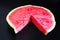 A large slice of watermelon divided into smaller pieces, flat, red, isolated on a black background, as a data chart