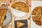 Large sliced Galician empanadas on a white table, a wooden table and black slate plates