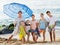 Large smiling family standing together on beach on summer day