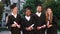 Large smiling multiracial students in their graduation day happy holding the diplomas and posing in front of the camera