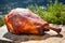 large smoked turkey leg resting on a stone slab