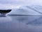 Large smooth iceberg in Twillingate Harbour with forested landscape on the horizon