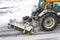 Large snow plowing tractor machine at work on the road during a snow storm in winter.