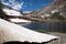 Large snowfields along the shores of Helen Lake in the Eastern Sierra Nevada Mountains of California, well into July summer