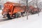 A large snowplow removes snow from the road