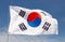 Large South Korea flag flying against sky and clouds closeup