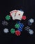 Large stack of different chips and the highest combination of playing cards in poker - royal flush isolated over black casino